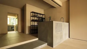A modern kitchen with a concrete countertop and minimalist design features.