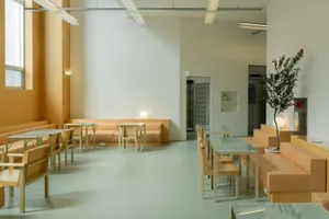 A modern lobby space featuring wooden furniture and seating.