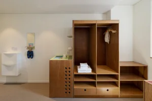 A minimalist closet with wooden shelves and clothing storage.