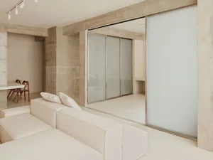 Modern minimalist living room with a white concrete couch and a sleek, futuristic design.