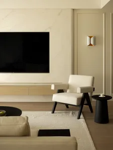 Modern minimalist living room featuring a marble wall and wooden furniture.