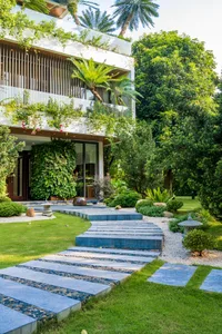 Modern residential exterior featuring concrete and lush greenery.