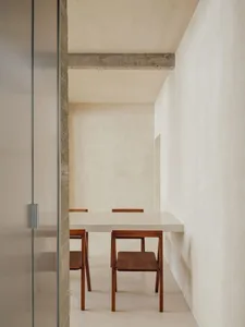 Minimalist interior with a concrete table and wooden chairs