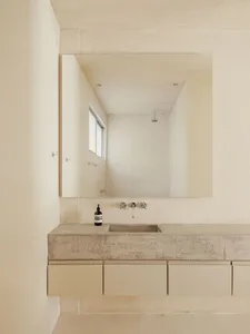 Modern minimalist bathroom with concrete sink and floating cabinet.