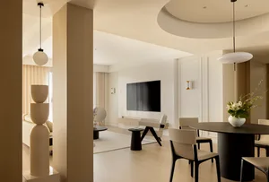 Contemporary living room with minimalist design, featuring a white marble floor, white marble coffee table, and white seating