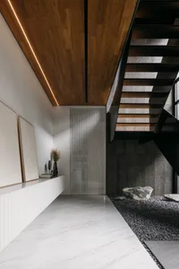 A sleek, modern staircase with white marble flooring and glass panels.