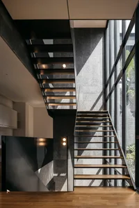 Modern staircase with glass and wood elements, illuminated by integrated lighting fixtures.
