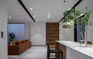 Modern, open-plan kitchen with white walls, wooden accents, and black seating.