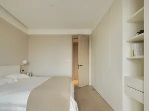 A minimalist bedroom with white and wood finishes