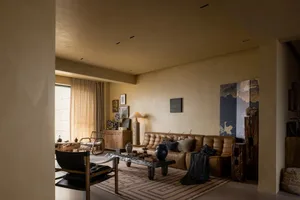 A modern living room with a leather sofa, industrial lighting, and art on the walls.