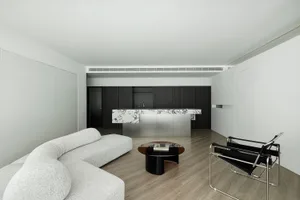 Modern living room with white furniture, concrete accents, and minimalist design