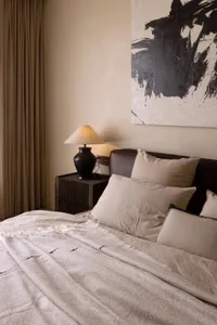Bedroom featuring minimalist design elements with fabric and leather textures