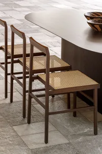 Modern dining room featuring cane woven seating and dark wood dining table.