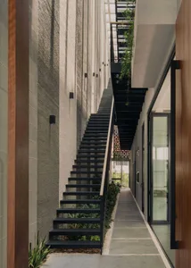 Modern interior design featuring black metal stairs with concrete risers and planters, set against a minimalist backdrop.