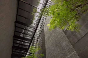 A modern interior space with a concrete wall and metal stairs.