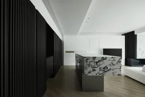 Modern kitchen featuring a marble countertop and dark wooden cabinets.