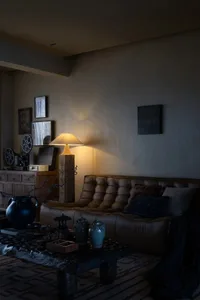 Modern leather sofa in an industrial-style living room setting with a wooden table and ceramic vases.