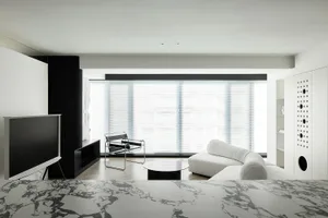 A modern living room with concrete walls and minimalistic furniture.