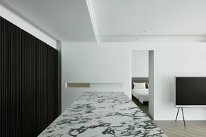 Modern minimalist apartment interior with marble floor and black, white, and gray color scheme.