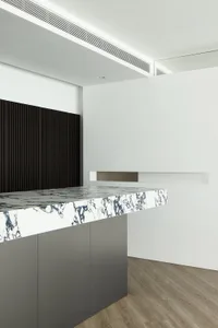 Modern office space with a marble countertop and dark wooden accents.