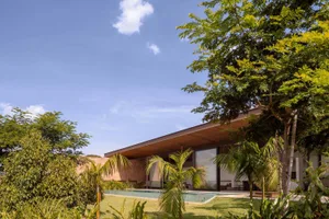 Modern residential exterior featuring concrete, glass, and wooden elements.