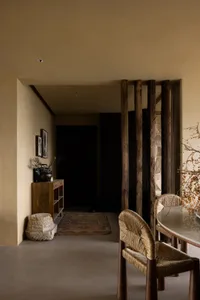 A modern residential space featuring wood, stone, rattan, and concrete materials.