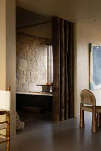 A residential interior space featuring a stone wall and concrete floor.