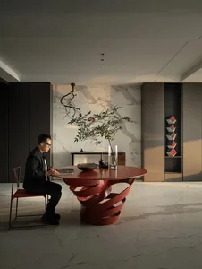 Man sitting at a minimalist office desk with a metal base and a marble top.