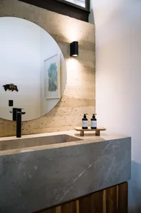 Modern bathroom with a marble sink and large round mirror