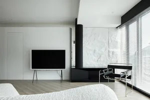 Modern minimalist bedroom featuring white walls and furniture.