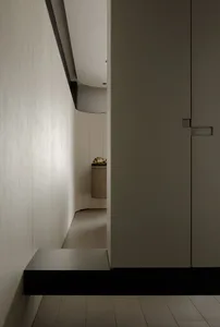 A modern minimalist hallway featuring ground wood and metallic elements.