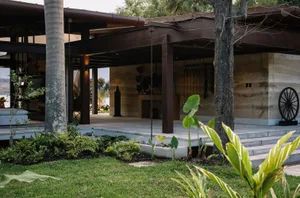 Modern residential exterior featuring concrete, stone, metal, and glass materials.