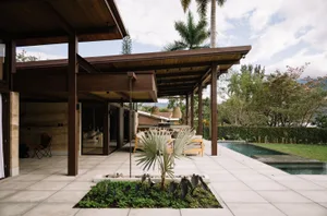 A modern residential exterior featuring concrete, wood, and glass materials.