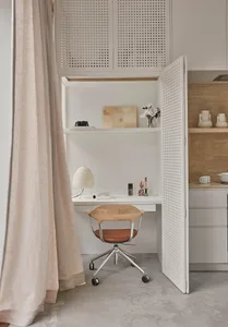 A minimalist home office with a desk, chair, and decorative items.