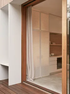 A modern minimalist kitchen with concrete flooring and wooden cabinetry.