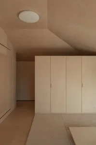 A minimalist room with wall closets made of birch plywood.