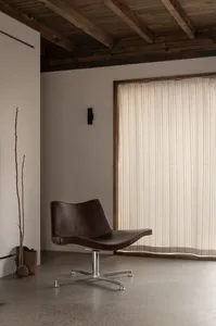 A modern interior living room with wooden furniture, minimalist decor, and a large window with vertical blinds.