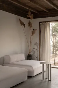 A minimalist living room with neutral-toned furniture and decor.