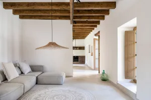 A minimalist living room with wooden furniture and a wicker lampshade