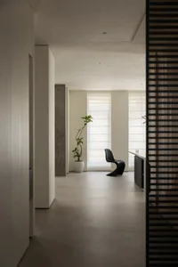 A minimalist living space featuring concrete walls and a glass window.