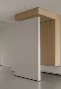 Modern minimalist interior featuring wooden furniture, concrete flooring, and white walls.