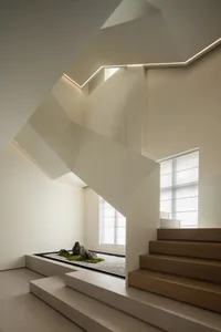 A modern minimalist white staircase in a white interior design setting.