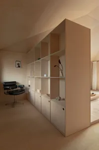 A minimalist office interior with wooden furniture and shelving.