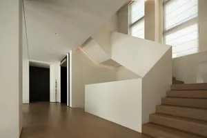 A modern residential staircase featuring concrete and wooden elements with built-in lighting.