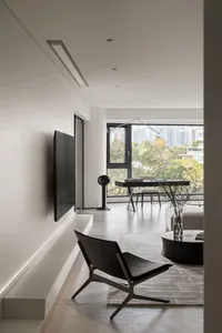 Modern minimalist living room featuring concrete and large glass windows.
