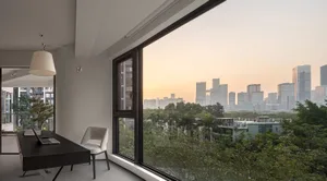 Modern interior with glass windows and wooden furniture looking out over a cityscape.