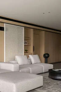 Modern living room with open concept, featuring a light-colored fabric sectional sofa and minimalist design elements.