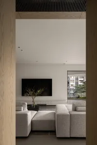 Modern living room featuring grey fabric sofas and a flat-screen TV.