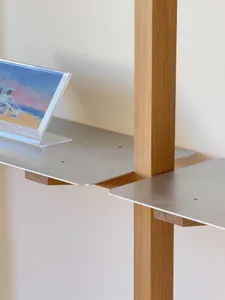 A modern metal desk with a clear acrylic frame holds a framed picture of a beach scene.