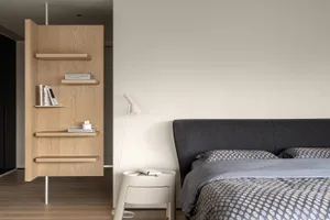 Modern minimalist bedroom featuring wood furniture, fabric bedding, and metal accents.